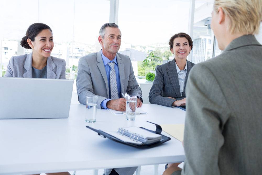 Professionals smiling interviewing a candidate